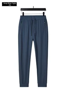 Detail of grey blue ice silk joggers showing elastic drawstring waist and zipper pocket
