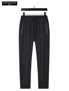 Detail of men's black ice silk pants showing zip pockets and elastic drawstring waist