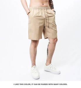 Detail of khaki cargo shorts featuring elastic drawstring waistband and side pocket detail