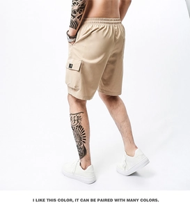Detail view of khaki cargo shorts with elastic drawstring waist and side flap pockets