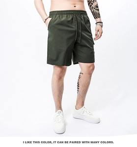 Detail view of military green cargo shorts with elastic drawstring waist and side pockets