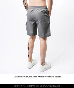 Men's grey cargo shorts detail featuring elastic drawstring waist and back patch pocket