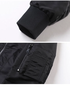 Detail of ribbed knit cuffs and tactical zipper sleeve pocket on a black flight jacket
