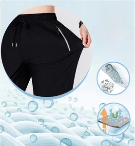 Detail of quick-dry pants with elastic drawstring waist and reflective zipper pocket