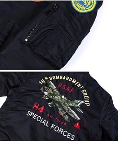 Détail de la broderie militaire et de la poche zippée sur un blouson aviateur noir