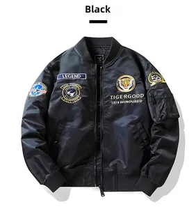 Detailed close-up of tiger embroidery and vintage badges on black pilot bomber jacket
