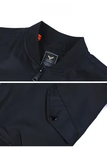 Detail of black bomber jacket showing ribbed collar, orange lining and snap pocket