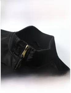 Detail of ribbed collar and metallic bronze zipper on a black pilot bomber jacket