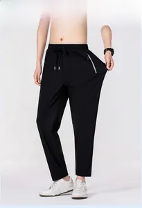 Close-up of men's quick-dry pants featuring elastic waist with drawstring and zip pockets