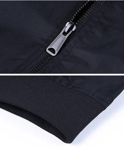 Detailed macro view of the metal zipper and ribbed cuff on a black pilot jacket