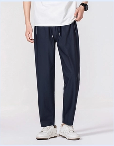 Detail of dark blue quick-dry pants featuring elastic drawstring waist and side silver stripes