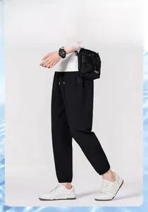 Detail view of men's black ice silk sports pants featuring elastic drawstring waist and pocket