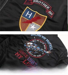 Detailed embroidery of shield emblem and helicopter print on black bomber jacket