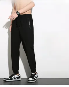 Detail of men's black ice silk sports pants with zippered pocket and elastic drawstring