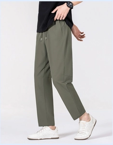 Détail du pantalon en soie glacée vert armée avec taille à cordon et poche zippée