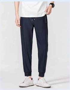 Detail view of navy blue ice silk joggers with side zipper pockets and ribbed cuffs