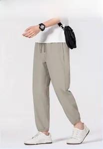 Detail of light khaki men's joggers showing elastic drawstring waist and lightweight fabric