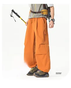 Détail d'un pantalon cargo outdoor orange avec taille élastique et poche zippée invisible