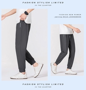Detail view of dark grey ice silk jogger pants with elastic ankle cuffs and zipper pockets