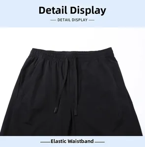 Détail du pantalon en soie glacée noire avec taille élastique et cordons de serrage réglables
