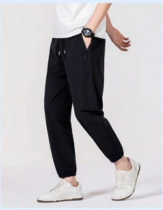 Detail of men's black ice silk pants showing drawstring waist and zipper pockets