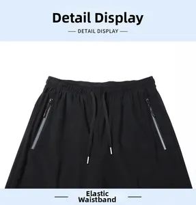 Detail view of elastic waist and zipper pockets on black quick-dry sports trousers