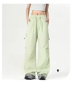 Detail showing elastic high waist and moisture-wicking fabric of light green cargo pants