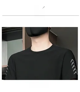 Detail of black sports T-shirt featuring classic crew neck and white dotted shoulder print