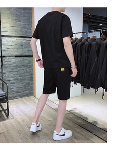 Detail view of the yellow woven label on the back pocket of men's black ice silk summer set