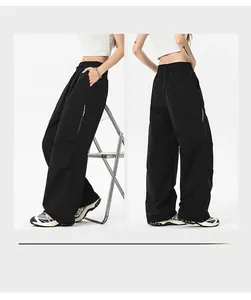 Detail view of black wide-leg cargo pants featuring side zipper pockets and elastic waist