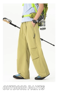 Détail d'un pantalon cargo outdoor avec taille élastique à cordon et poche zippée latérale
