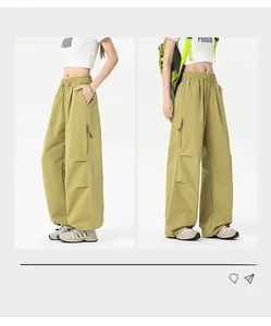 Detail of loose fit outdoor utility pants in mustard green with zip cargo pockets