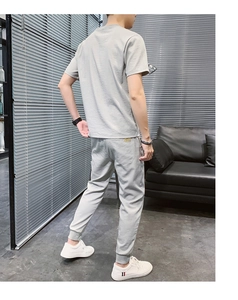 Completo casual da uomo in seta di ghiaccio grigio con t-shirt e pantaloni, vista laterale