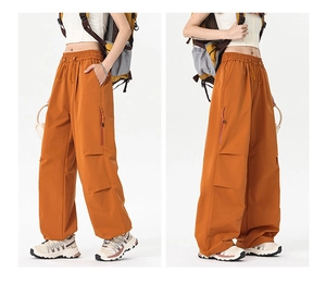 Detail view of mustard yellow cargo pants with elastic drawstring waist and side zip pockets