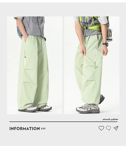 Détail du pantalon cargo vert clair montrant les poches zippées et la taille à cordon
