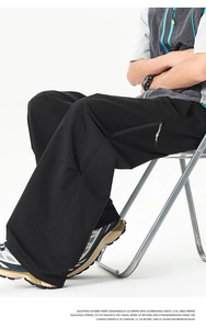 Détail de la poche zippée invisible sur le pantalon cargo noir à jambes larges