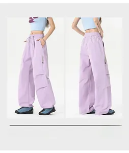 Detail view of light purple loose-fit cargo pants with side zipper pockets and drawstring
