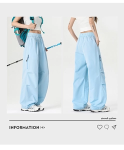Detail of light blue outdoor cargo pants featuring elastic drawstring and zip pockets