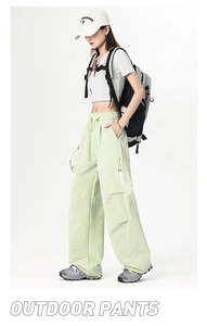Detail of mint green outdoor cargo pants with elastic drawstring waist and side zip pockets