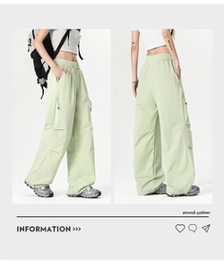 Detail view of light green cargo pants with elastic waist and side zipper pocket