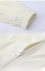 Detail of elastic cuffs and smooth zipper on beige lightweight sun protection jacket