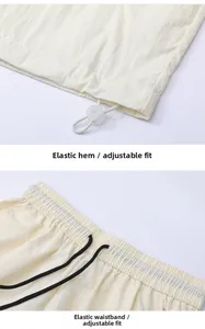 Detail of adjustable elastic hem with toggle and waistband with black drawstring on off-white shorts