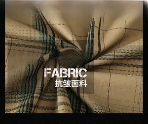 Detailed macro shot showing the soft texture and khaki plaid pattern of the cotton shirt