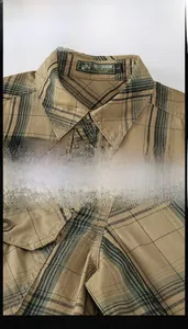 Detail view of khaki plaid cotton shirt showing woven label and metal button texture
