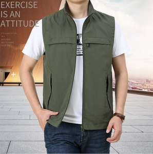 Detail of green functional outdoor vest showing zip pockets and water-resistant fabric