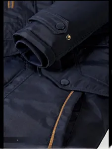 Detail of ribbed windproof cuffs and buttoned pockets on navy blue winter jacket