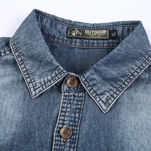 Detail of washed denim shirt collar with outdoor label and vintage metal buttons