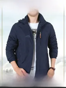 Detail of dark blue outdoor hooded jacket featuring chest logo and vertical zipper pocket