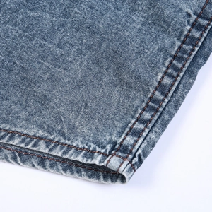 Detail of dark blue washed denim shirt featuring reinforced orange contrast double stitching