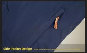 Macro detail of side zipper with brown leather pull and embossed Outdoor text on navy jacket